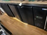 trois réfrigérateurs noirs posés sur un comptoir en bois