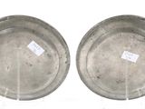 pair of silver plates with labels on them on a white surface