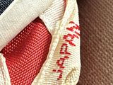 a hand holding a red and white tie with a red heart on it