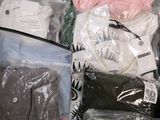 a lot of clothes in a plastic bag on the floor