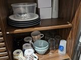a wooden cabinet with dishes and cups on it