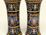 pair of black and gold vases with designs on them on a white background