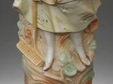 statue of a woman in a dress and hat holding a broom