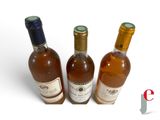 three bottles of wine sitting next to each other on a white surface