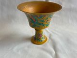 un vase jaune orné d'un motif bleu et vert