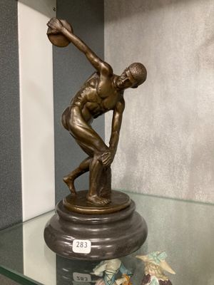 a bronze statue of a man holding a baseball bat