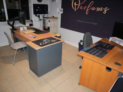 a desk with a computer and a chair in a room