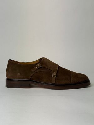 the shoe is brown sued and has a buckle on the side