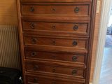 une commode avec un miroir et une valise posée par terre