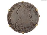 une vieille pièce d'argent sur laquelle figure la tête d'une femme coiffée d'une couronne