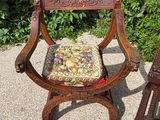 a wooden chair with a cushion on it next to a wooden chair with a cushion on it