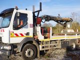 un camion blanc avec une grue à l'arrière