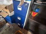 a blue filing cabinet in the corner of a room filled with boxes