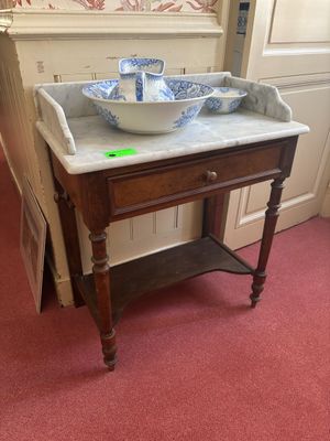 a marble sink on a wooden table in a room