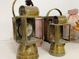 two brass lanterns sitting next to each other on a table