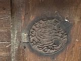 a close up of a wooden door with a carved medallion on it