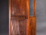 an old wooden cabinet with a glass door on top of it