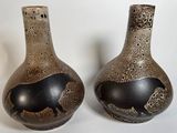 deux vases posés l'un à côté de l'autre sur une table