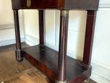 a wooden table with a shelf underneath it on a wooden floor