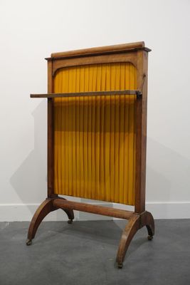 une photo d'une chaise en bois jaune dans une pièce aux murs blancs