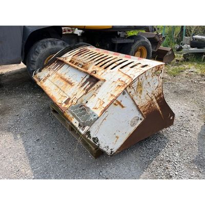 un objet métallique rouillé posé par terre à côté d'un camion