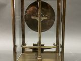 an image of a brass clock with a glass case and a bell
