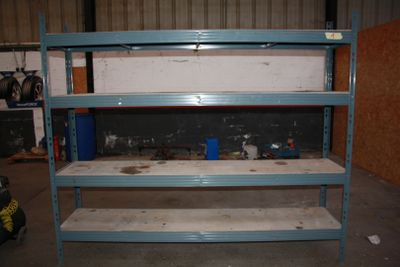 une étagère bleue dans un garage, sur laquelle sont posés des outils