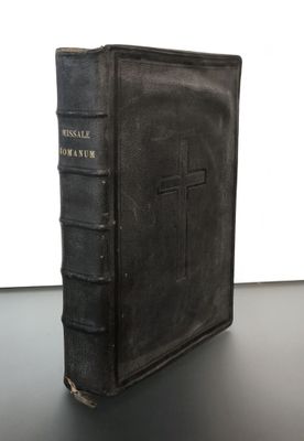 un vieux livre orné d'une croix, posé sur une table