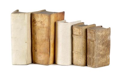 several old books are lined up in a row on a white surface