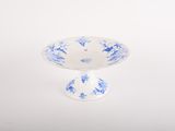 small blue and white footed bowl on a white background