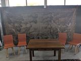 trois chaises et une table devant une tapisserie
