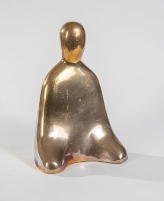 une image représentant une figurine en or posée sur une surface blanche