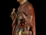 an old statue of a man holding a bird on a black background