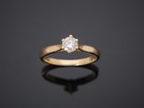 a single stone diamond ring on a black surface