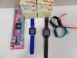 Plusieurs montres pour enfants et une paire de ciseaux sont posés sur une table