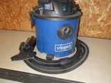 un aspirateur bleu et noir posé sur un plan de travail