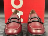 une paire de chaussures rouges à semelles noires posée sur une boîte rouge