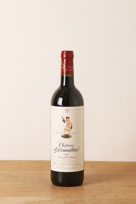 la bouteille de vin rouge est posée sur une table en bois