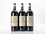 trois bouteilles de vin rouge posées l'une à côté de l'autre sur une surface blanche