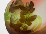 a glass vase with butterflies on it on a table