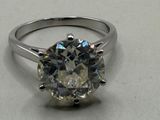 a close up of a diamond ring on a white surface