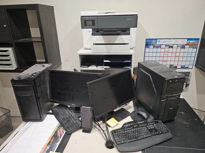 un bureau sur lequel se trouvent deux ordinateurs et une imprimante
