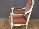 an old chair with a red upholstered seat sits on a parquet wood floor