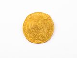 gros plan d'une pièce d'or sur une surface blanche