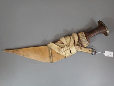a wooden knife with a brown handle on a gray surface