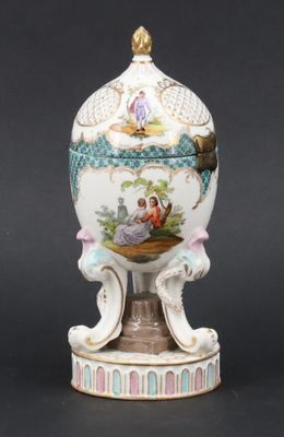 a white and blue vase with a bird on top of it