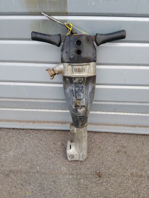 une perceuse posée par terre à côté d'une porte de garage