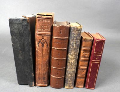 plusieurs vieux livres sont alignés sur une surface grise