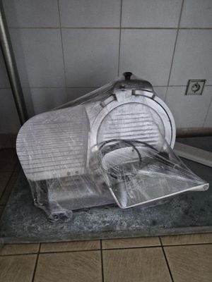 un couvercle en plastique posé sur un coupe-pizza posé sur un plan de travail