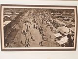a black and white photo of a street with people walking on it